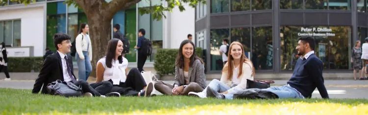 students sitting on the grass